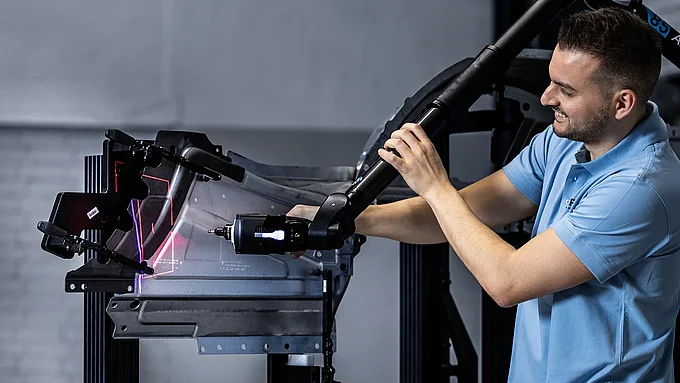 Mitarbeiter führt Lasermessung eines Bauteils durch