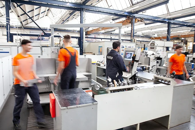 Vier Auszubildende Zerspanungsmechaniker arbeiten in der Ausbildungswerkstatt