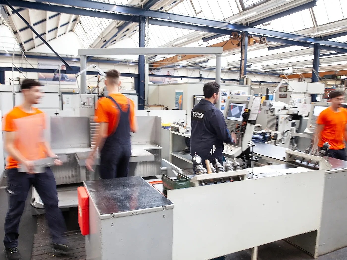 Vier Auszubildende Zerspanungsmechaniker arbeiten in der Ausbildungswerkstatt