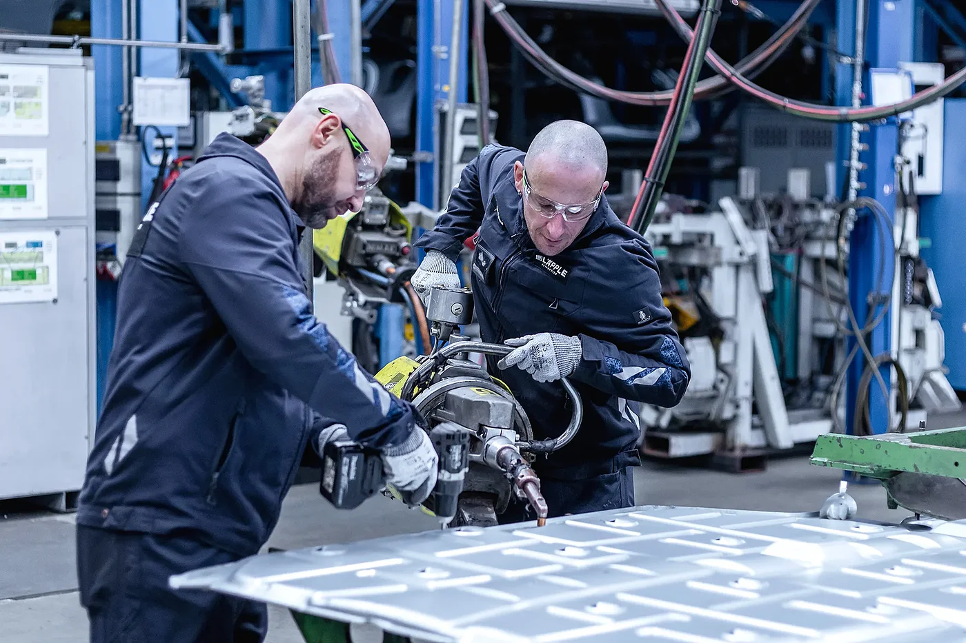 Mitarbeitende arbeiten mit Schrauber und Schweißzange an einem Prototypen