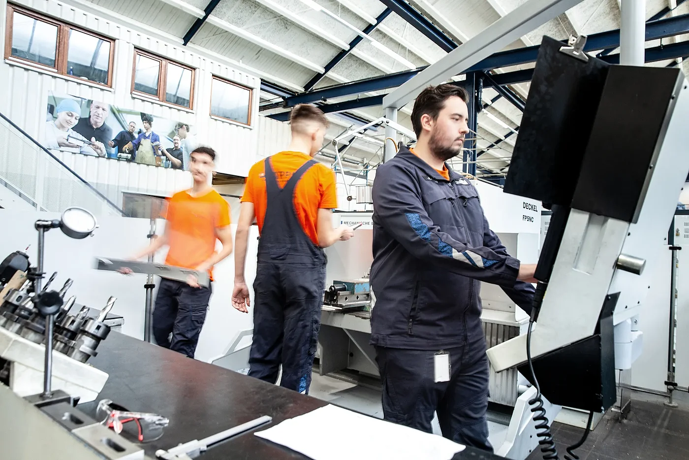 Drei Auszubildende Zerspanungsmechaniker arbeiten in der Ausbildungswerkstatt