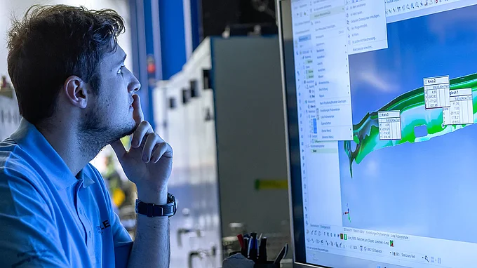 Mitarbeiter der QS schaut sich die Ergebnisse des Laserscans an