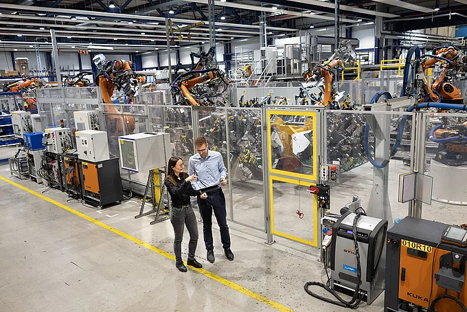 Gespräch zwischen zwei Mitarbeitenden zum KI Einsatz in der Produktion